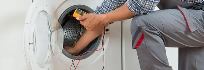 Dryer repair technician inspecting and repairing a clothes dryer in Shreveport, LA