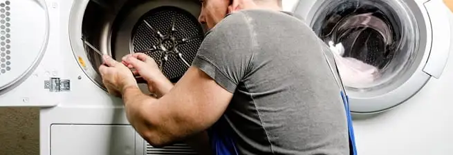 Dryer repair technician fixing a clothes dryer drum in Shreveport, LA