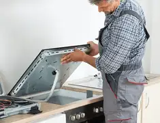 Appliance repair technician installing a built-in cooktop in Shreveport, LA