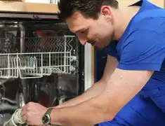 Dishwasher repair technician inspecting and servicing an open dishwasher in Shreveport, LA