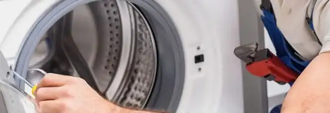 Appliance technician repairing a clothes dryer drum and internal parts in Shreveport, LA