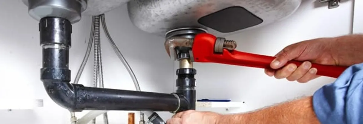 Garbage disposal repair technician tightening the sink drain and disposal connection in Shreveport, LA