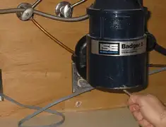 Garbage disposal repair technician tightening the mounting ring under a sink in Shreveport, LA