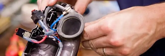 Vacuum repair technician reconnecting wiring and components in Shreveport, LA