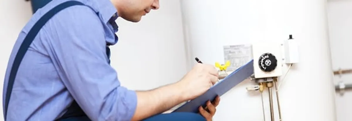 Water heater repair technician inspecting the unit and recording service notes in Shreveport, LA
