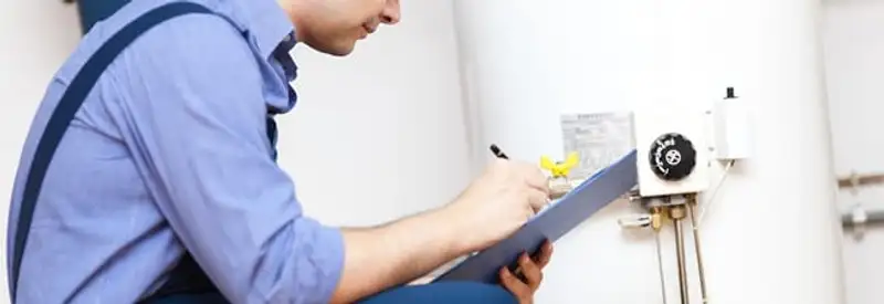 Water heater repair technician inspecting the unit and recording service notes in Shreveport, LA