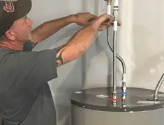 Water heater repair technician tightening supply line connections in Shreveport, LA